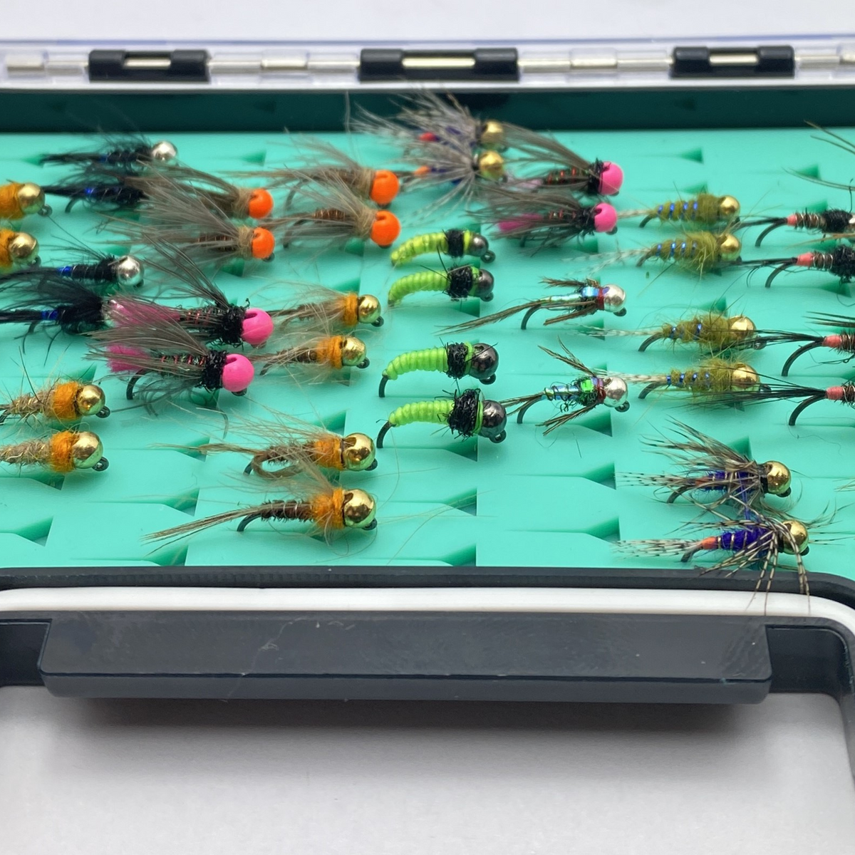 Assorted fishing lures on a green and black holder