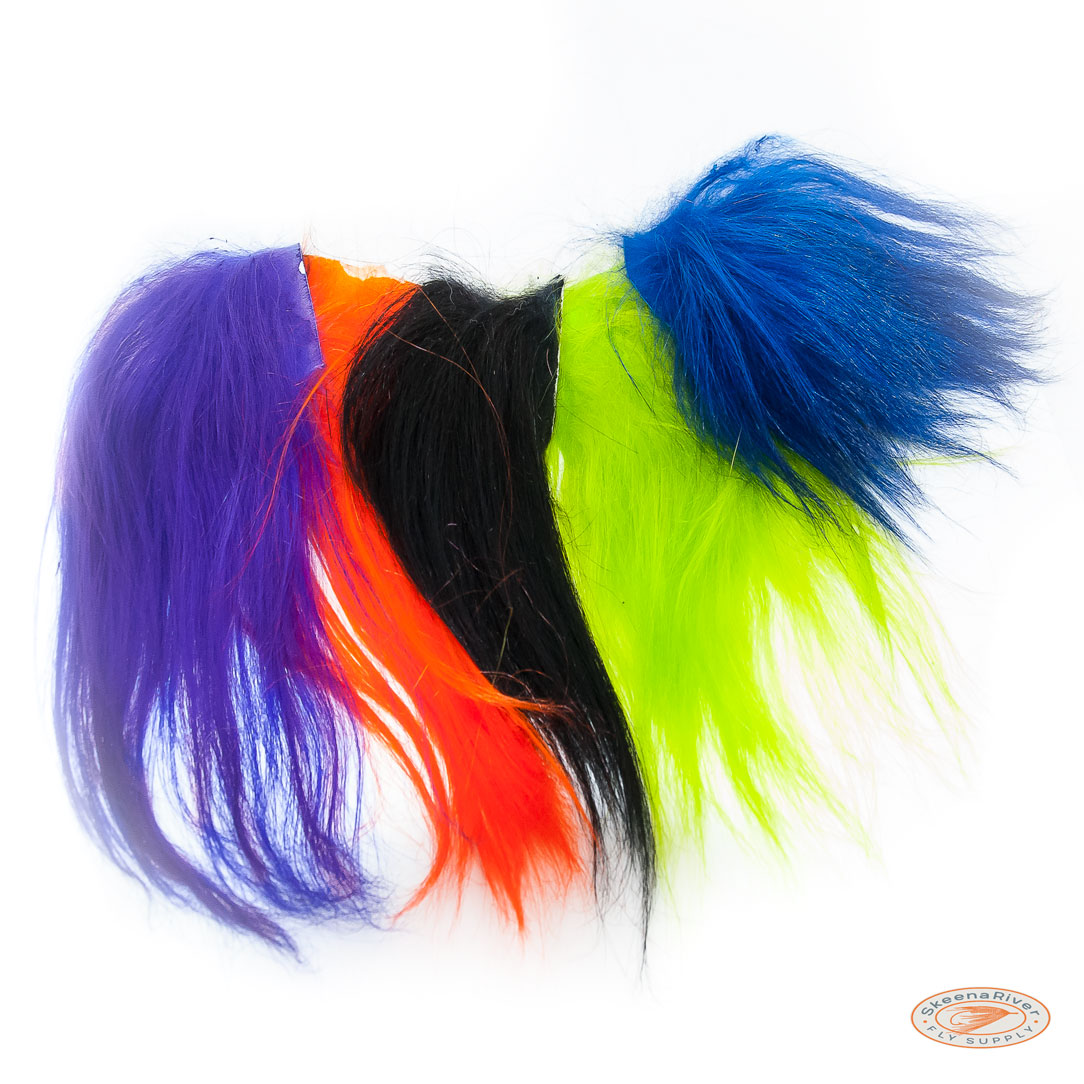 A collection of vibrant colored Himalayan Mountain Goat fur and hair, used for fly tying materials. The fur is soft and long, with a shiny texture, displayed in various bright colors including purple, blue, green, orange, black, and yellow.