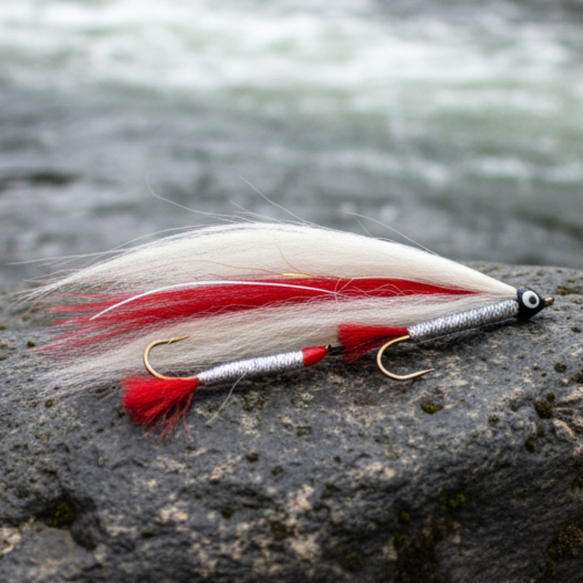 Fishing lure with red and white feathers on a light gray background