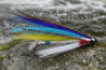 Colorful fishing fly with a hook on a light gray background