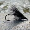 Black fly fishing lure on a tiled surface