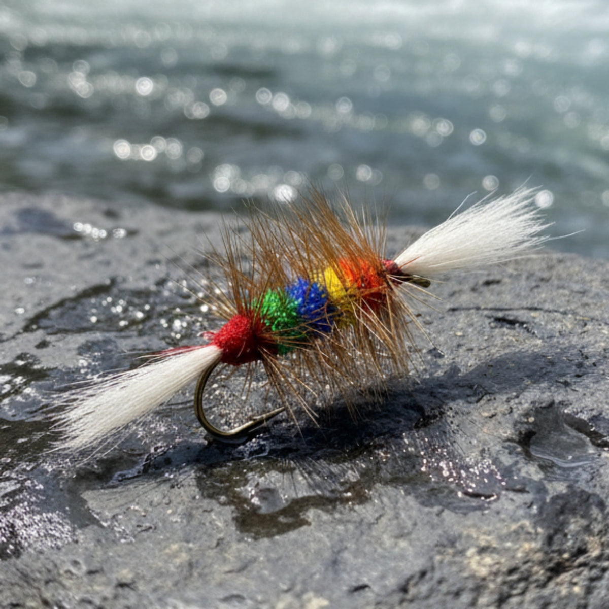 salmon bomber in multiple colors with a white tail and wing resting on a river rock