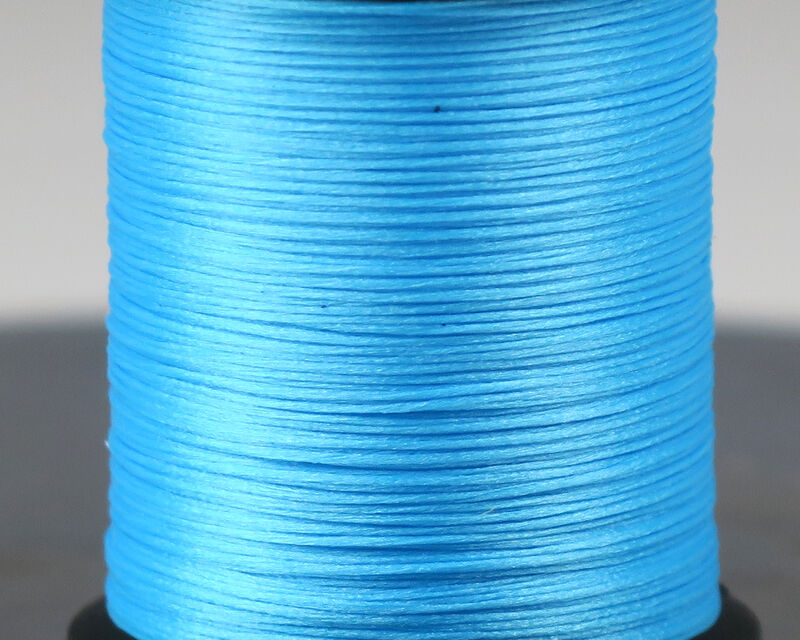 Spool of blue thread on a gray background