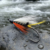 Fishing fly with colorful feathers on a white background