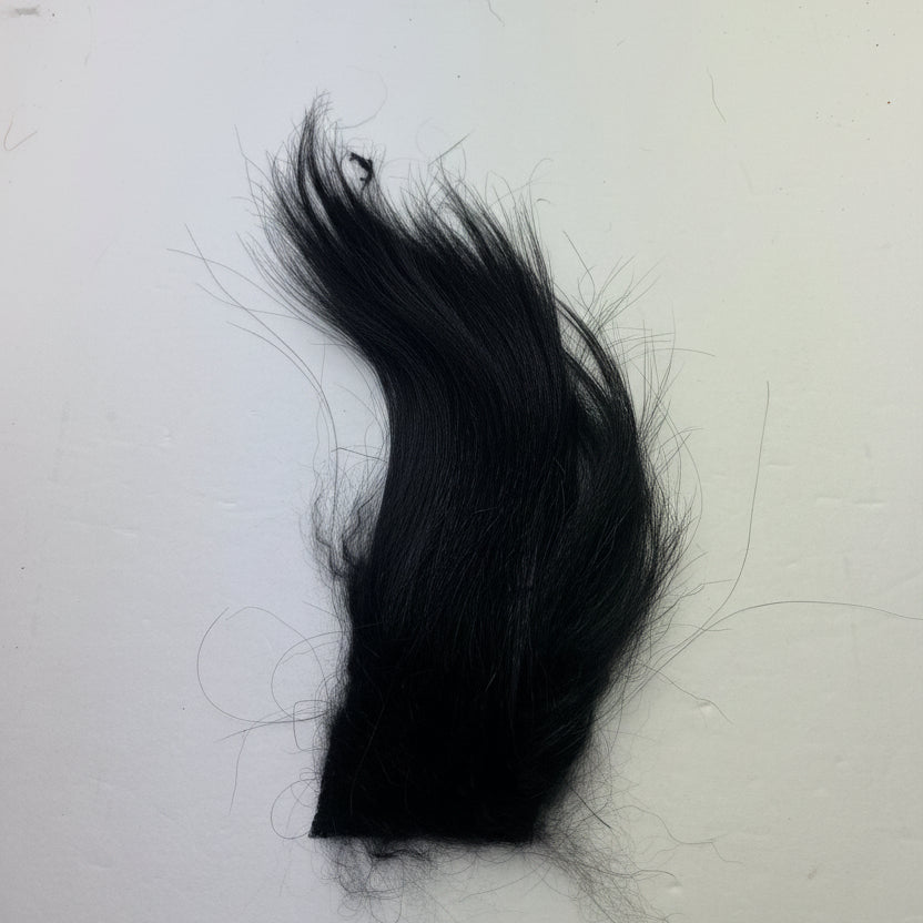 Fly tying material, arctic goat hair in black on a white background