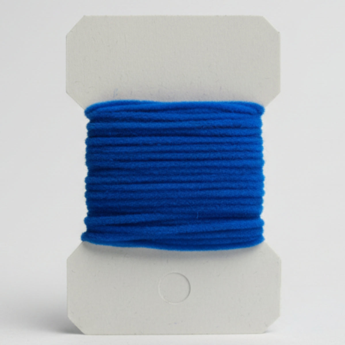 Blue thread on a white spool against a light gray background