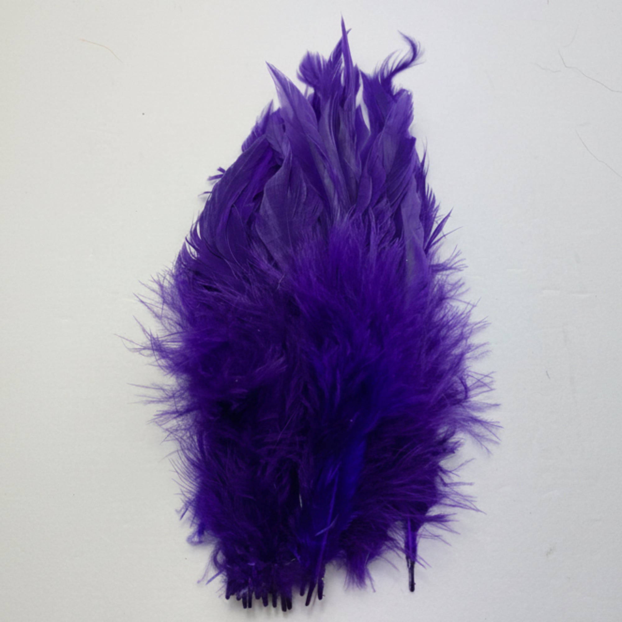 Purple feathered item on a white background