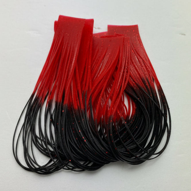 Fly tying material. Wapsi sili legs - silicone legs black with red tips on a white background