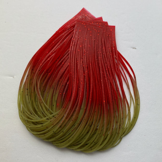A translucent silicone fishing lure skirt with a red-to-olive green gradient, displayed on a plain off-white background.