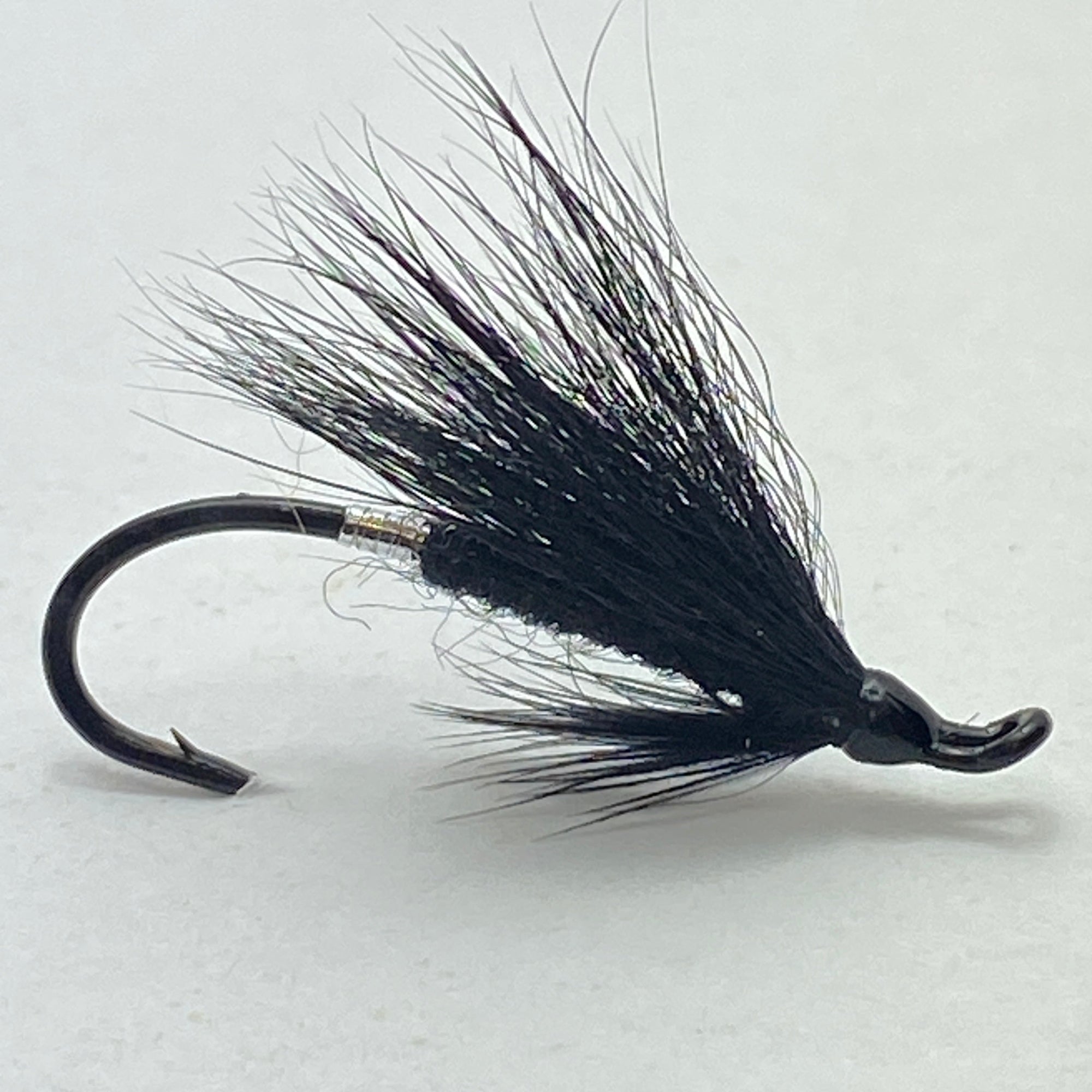 Black fly fishing lure on a white background