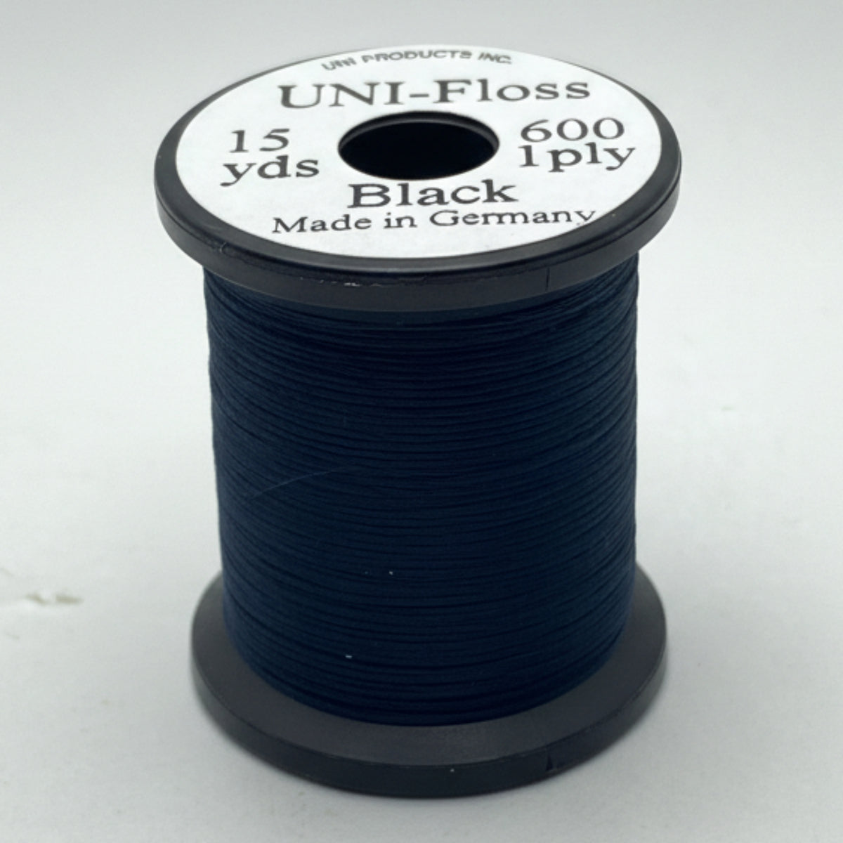 Spool of black thread with label on a white background