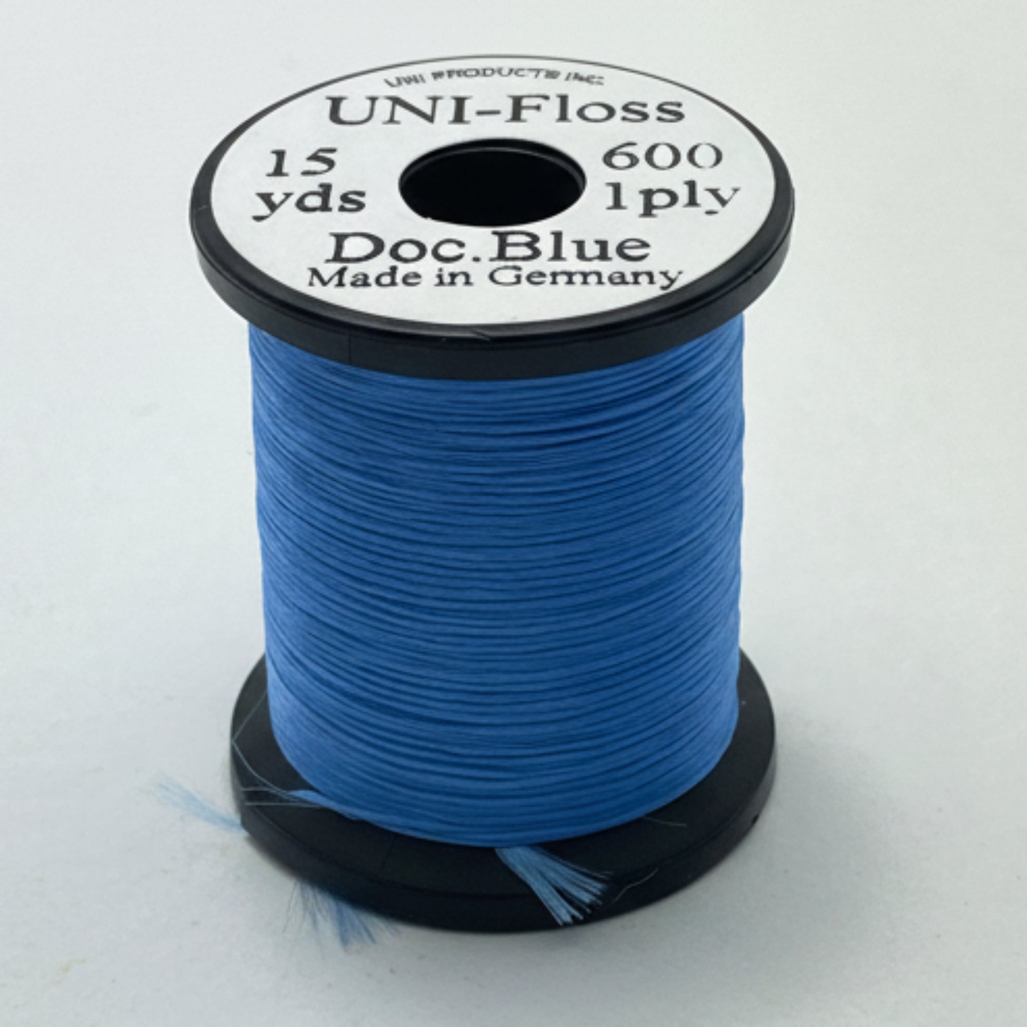 Spool of blue thread with a black and white label on a light gray background