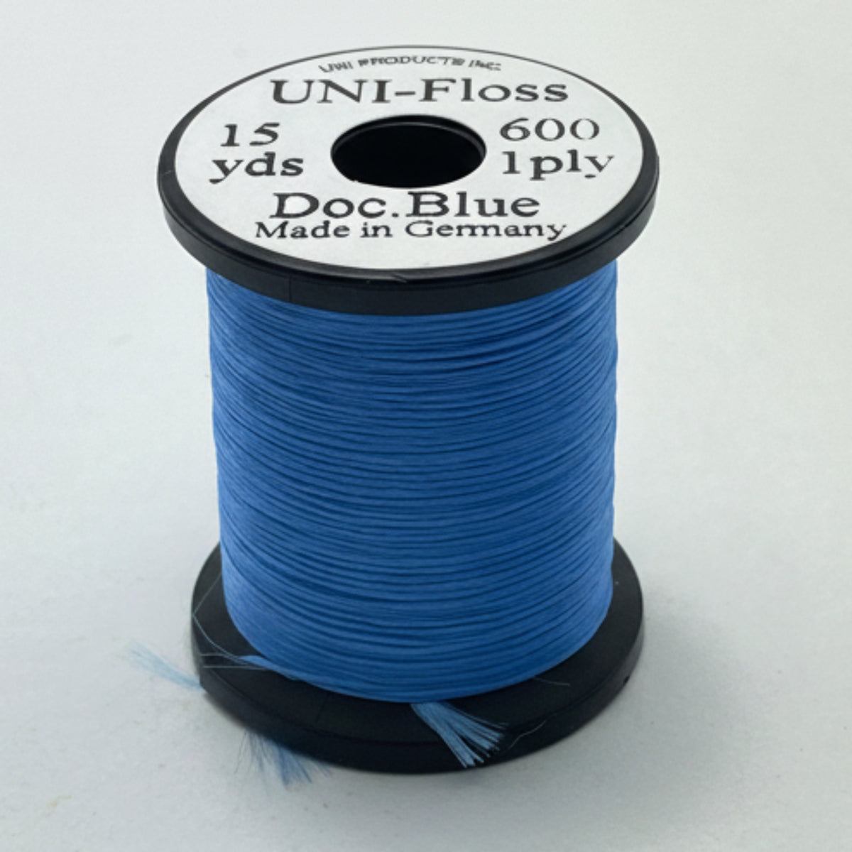 Spool of blue thread with a black and white label on a light gray background