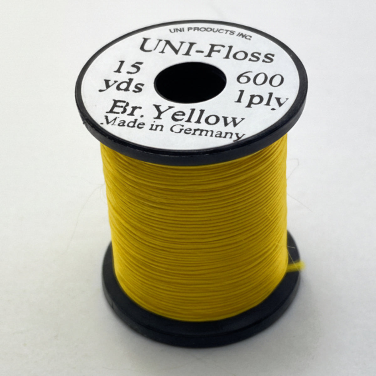 Spool of yellow thread with a black and white label on a white background