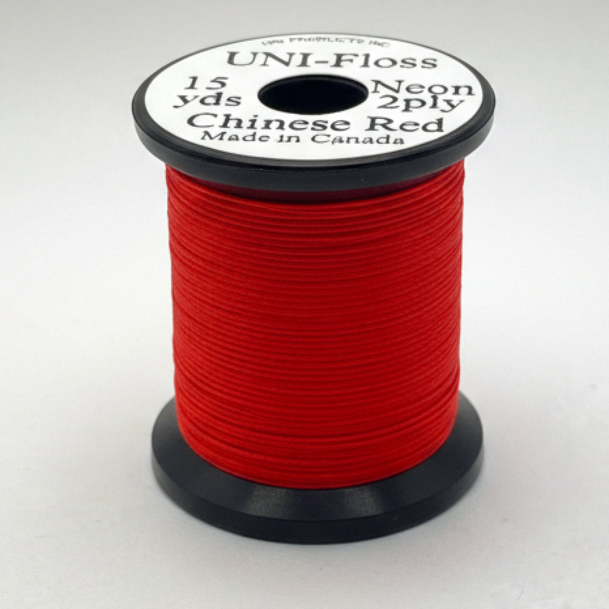 Spool of red thread with a label on a white background