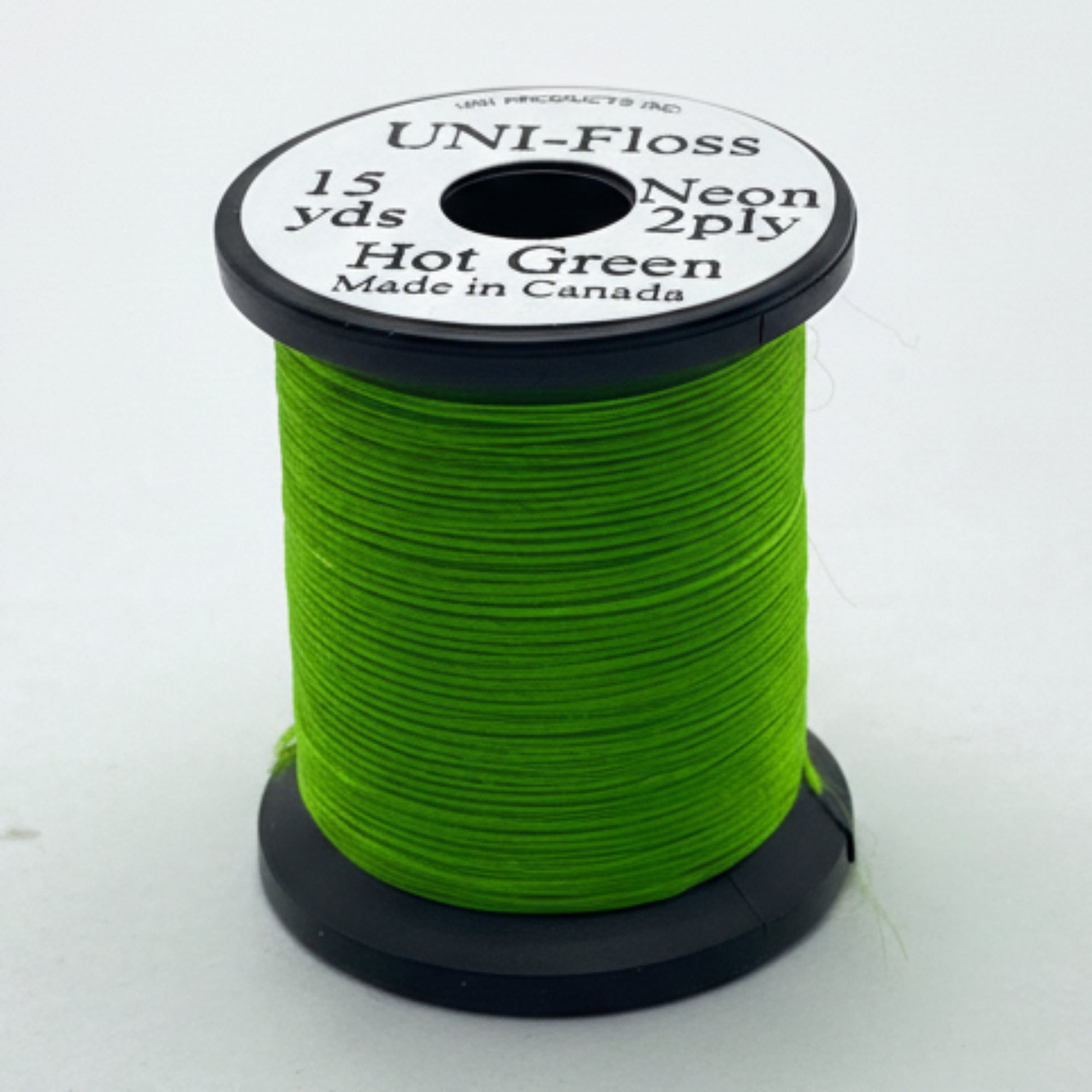 Spool of green thread with a label on a white background