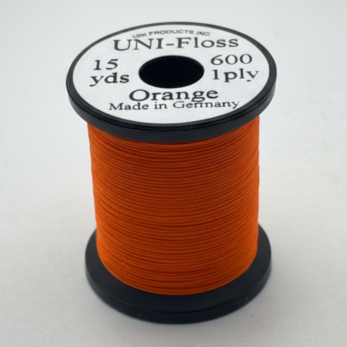 Spool of orange thread with a black and white label on a white background