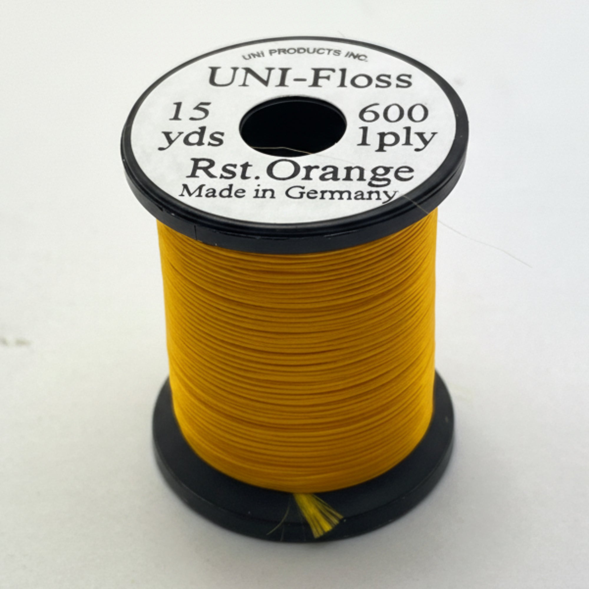 Spool of yellow thread with a black and white label on a white background