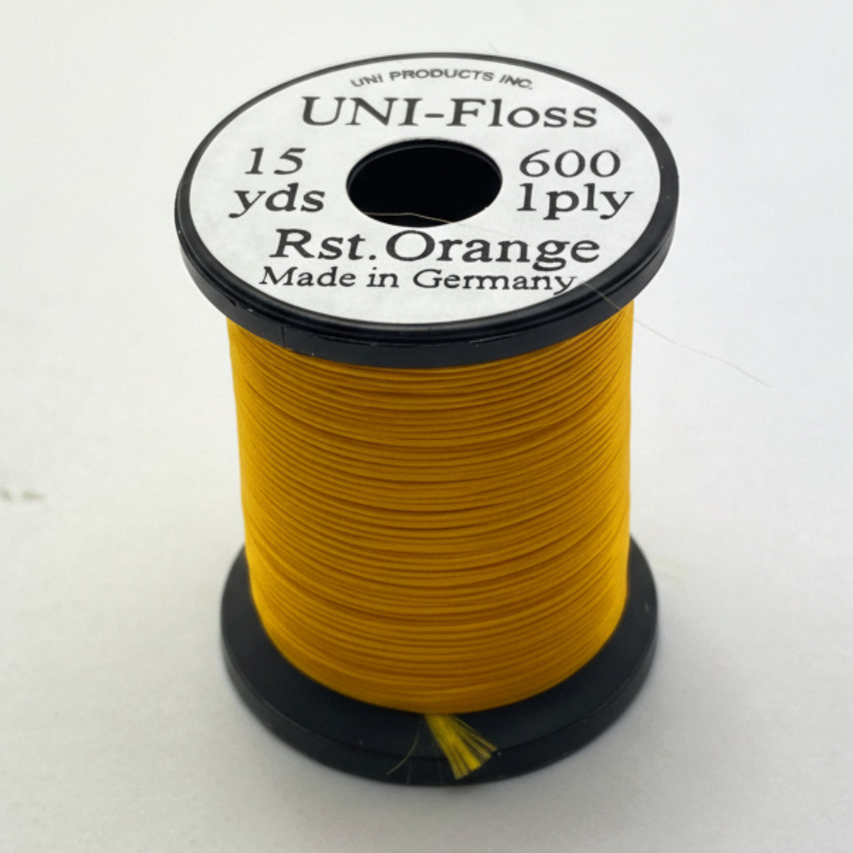 Spool of yellow thread with a black and white label on a white background