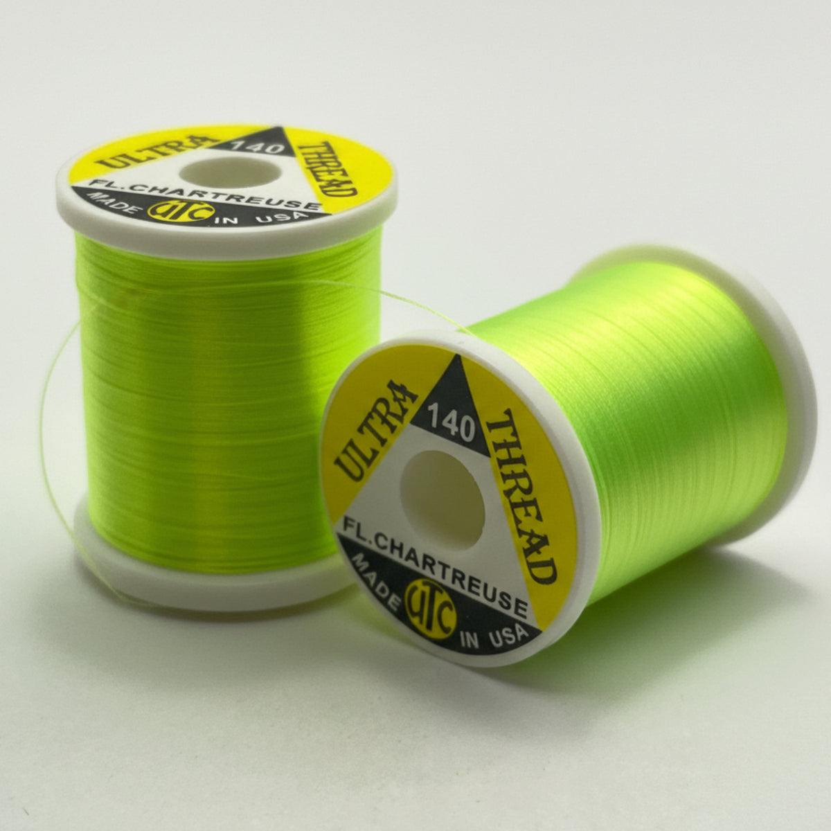 Two spools of chartreuse thread with visible branding on a white background